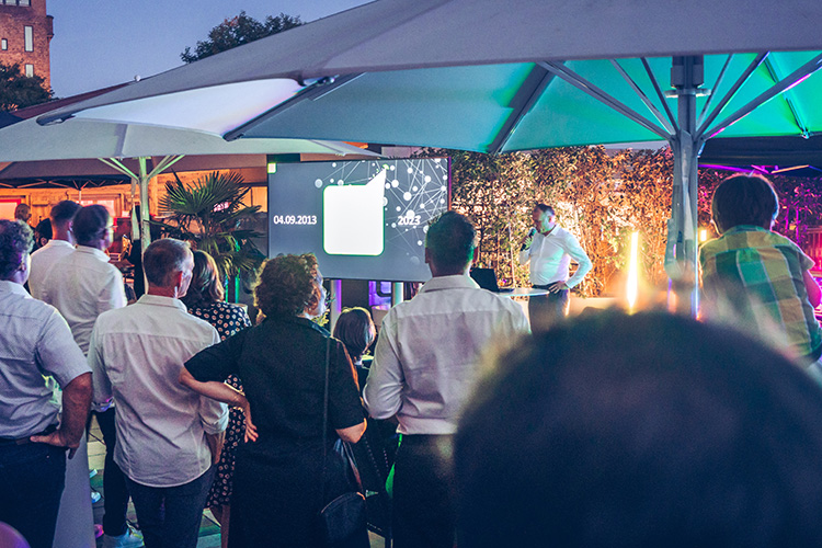 Impression of the anniversary celebration, Jobst Eßmeyer is shown giving a speech to the audience